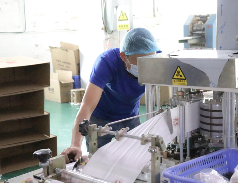quality control worker inspecting toilet paper production process